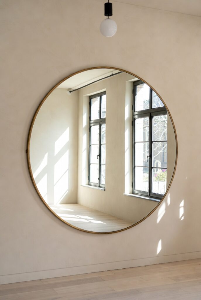 Oversized Round Gold Mirror in Bright Modern Interior Reflective Elegance Home Design
