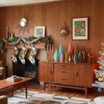Mid mod Christmas decor setup with silver tree and retro styled mantel in a living room.